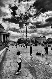 Street performer blows bubbles in Trafalgar Square
